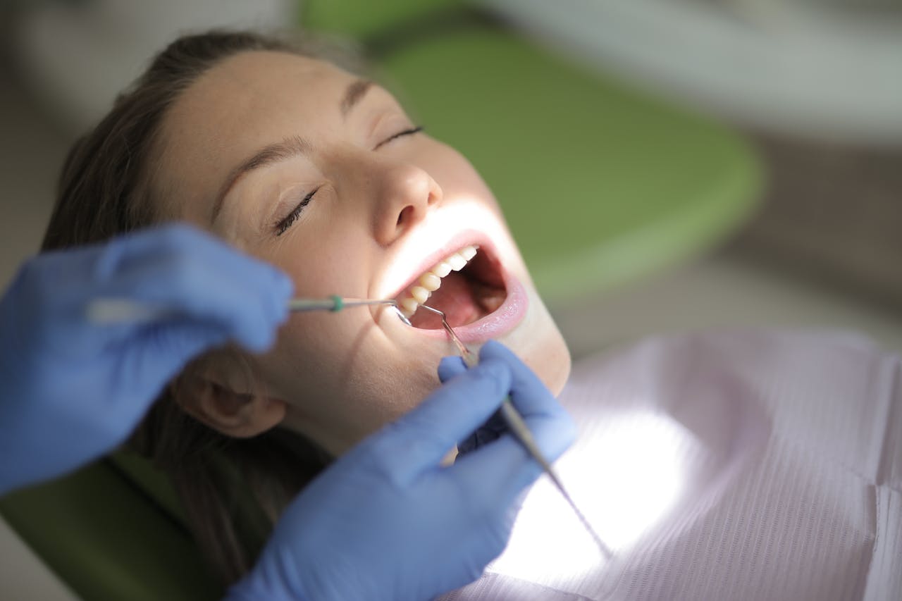 Close-up of a dentist performing a dental check-up on a woman patient in a clinic.
